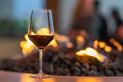glass of red wine in front of fire pit