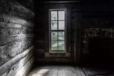 In front of window and chimney inside John Oliver Cabin